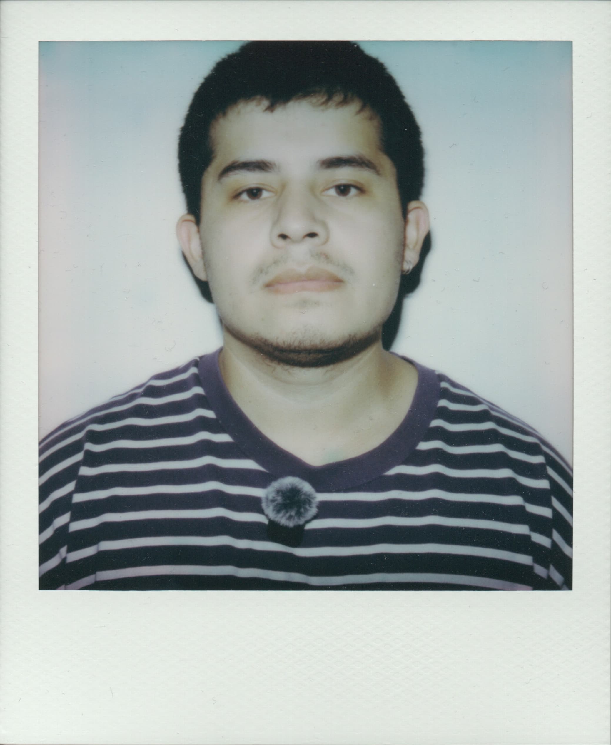 Abrahan Garcia holding a Polaroid self-portrait